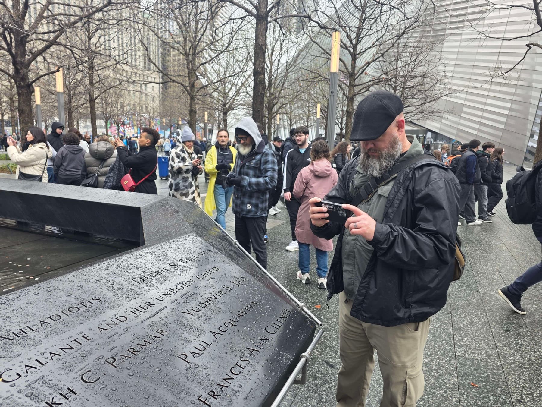 A filmmaker gathering visual notes beside the engraved names at the 9/11 Memorial